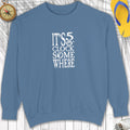 Blue sweatshirt with 'It's 5 o'clock somewhere' text on a wooden surface.