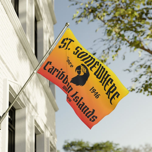 Flag with text and logo on a building with trees in the background