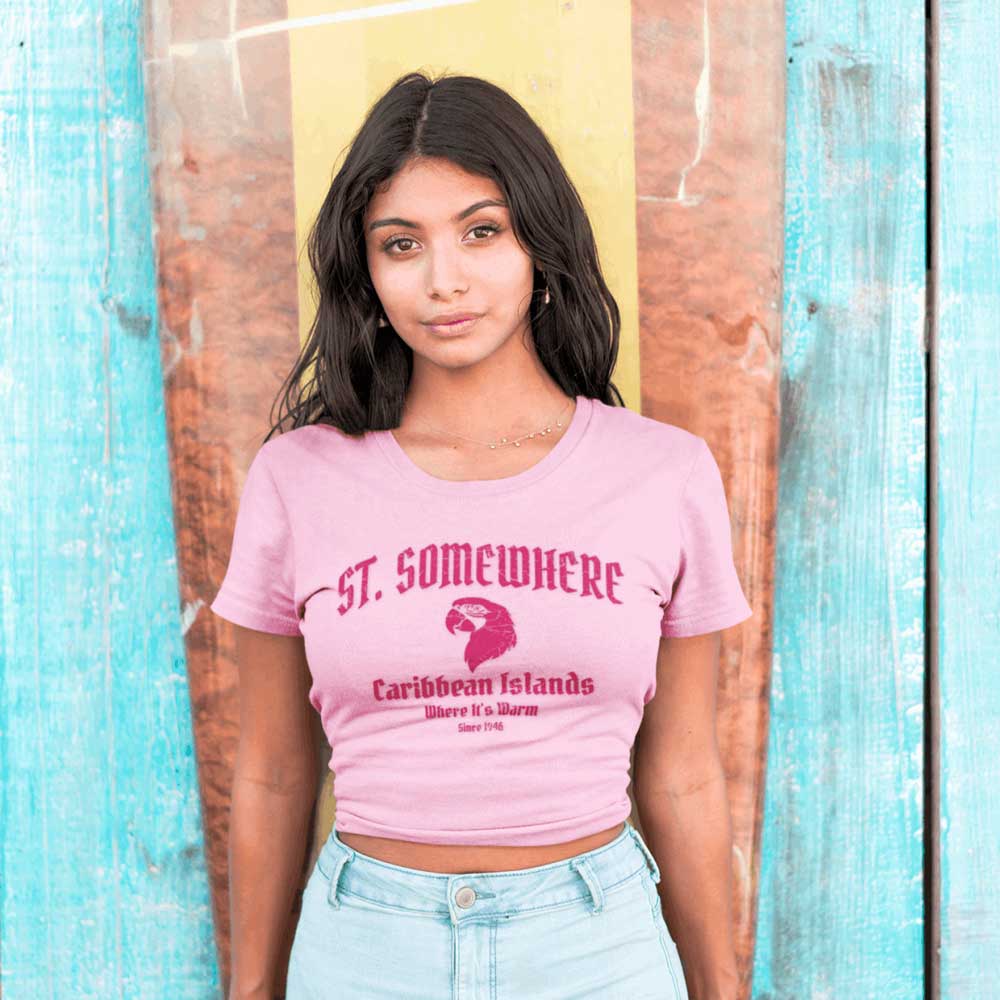 Woman wearing a pink t-shirt with text and graphics against a wooden background