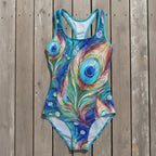 One-piece swimsuit with peacock feather design on a rustic wood background