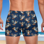 duce wearing navy swim shorts with pelican pattern on a beach background