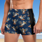 dude wearing navy blue swim shorts with pelican pattern on a beach.