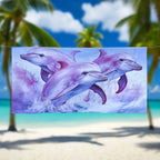 Pink and purple dolphins on a on a sweet beach towel hanging on a close line in a tropical paradise