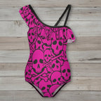 Pink Pirate swimsuit with black skull and crossbones pattern on nautical wood background