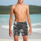 Young Dude wearing black and gray pirate skull-patterned swim shorts on a beach in St. Croix