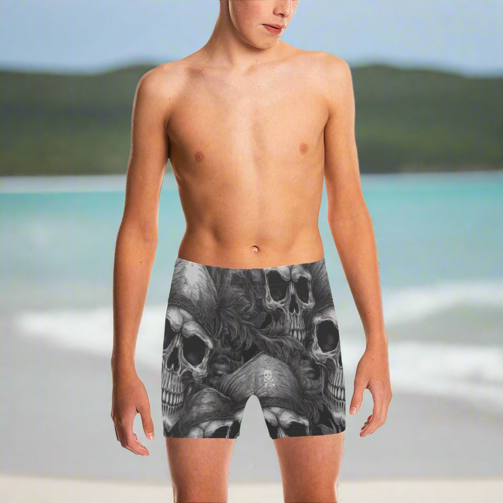 Young Dude wearing black and gray pirate skull-patterned swim shorts on a beach in St. Croix
