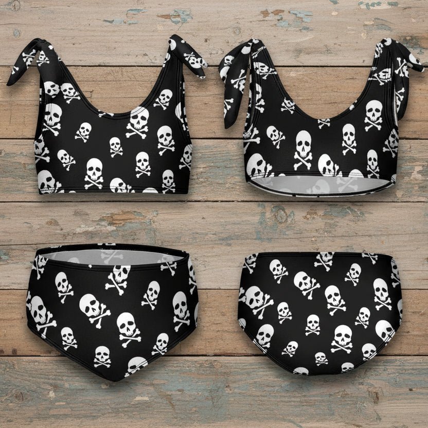 Black bikini set with skull and crossbones pattern on nautical wood background