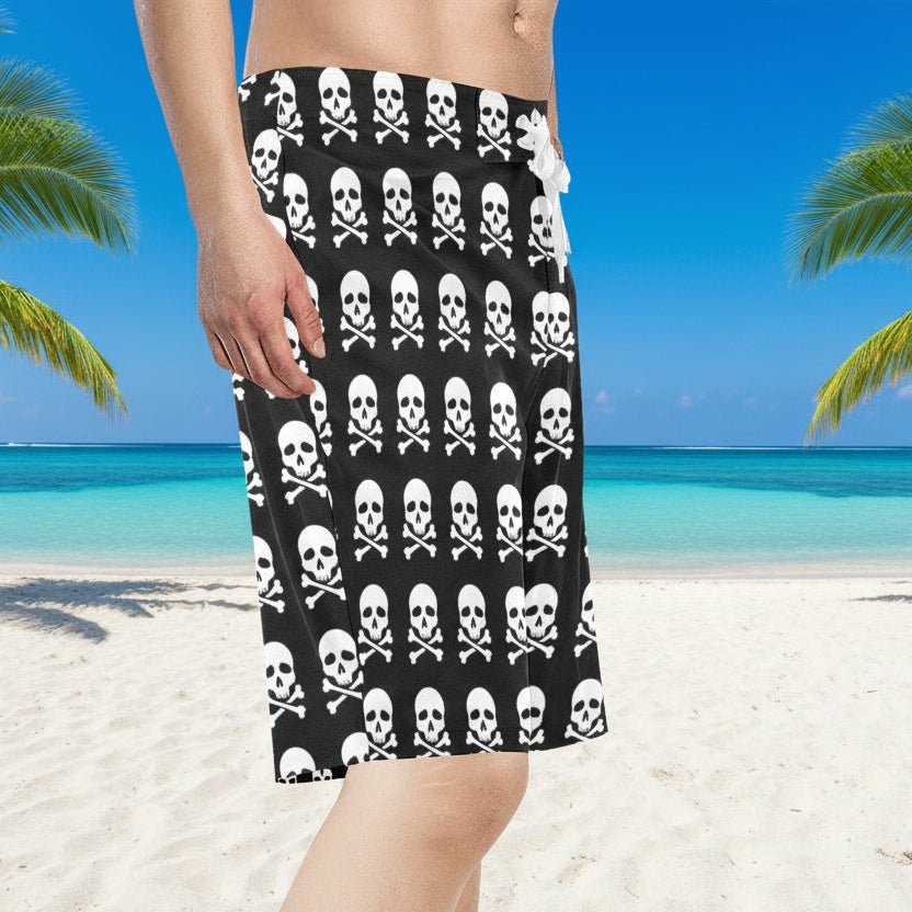 Black board shorts with white skull and crossbones pattern worn by a dude on a  Caribbean Beach