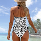 Woman in a skull-patterned swimsuit on a tropical beach