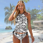 Woman wearing a black and white skull-patterned swimsuit on a beach.