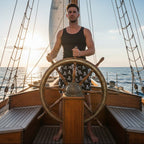 Black shorts with white skull and crossbones pattern worn by a dude at the helm of a vintage sailboat