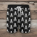 Black shorts with white skull and crossbones pattern on a rustic nautical wood background