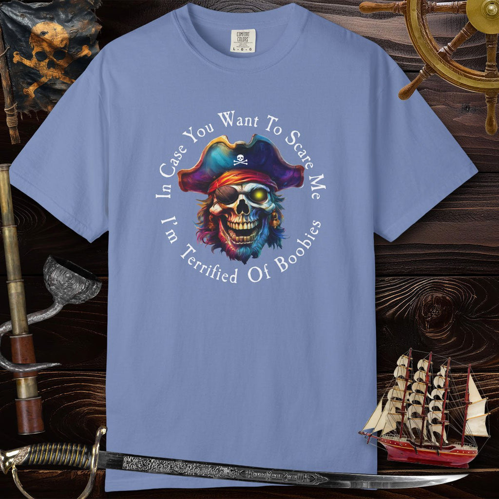 Blue t-shirt with a pirate-themed graphic and text on a wooden background with ship and sword.