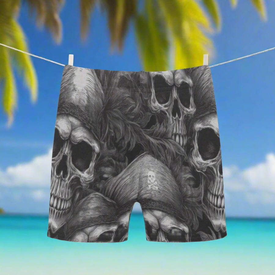Black and white graphic design of skulls on on boys' swimming shorts hanging on a line on a Caribbean island beach
