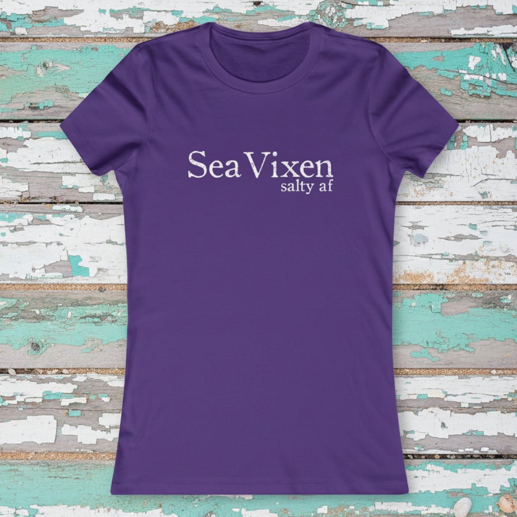 Purple t-shirt with 'Sea Vixen salty af' text on a rustic nautical wood background