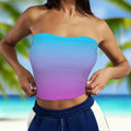 Gradient purple to sky blue strapless top worn by a beachwear model against a beachy background