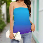 Swimwear model wearing a blue to purple gradient strapless top with jeans and holding a white clutch standing on a sidewalk in Key West