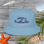 Light blue bucket hat with text on a wooden background with fishing-related items.