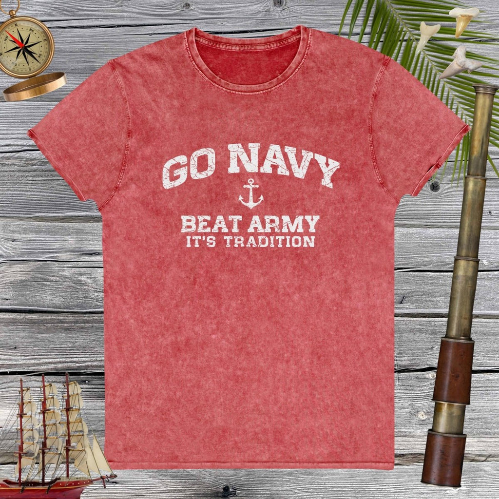 Red denim t-shirt with 'Go Navy, Beat Army, It's Tradition' text on a wooden background.