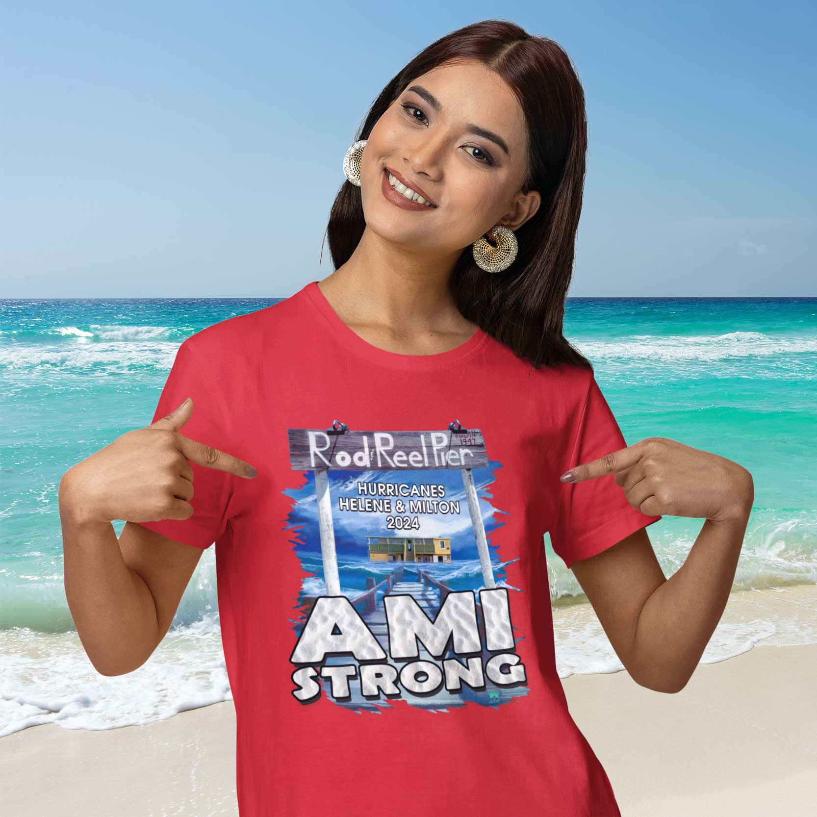 Woman wearing a red 'AMI STRONG' t-shirt on a beach