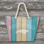 Striped beach bag with 'Respect the Locals' text and manatee graphic on a white background