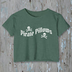 Green t-shirt with 'Pirate Pillows' text and skull design on a rustic wood background
