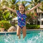 Colorful swimsuit with manatee design on a girl jumping into a pool in a tropical island resort