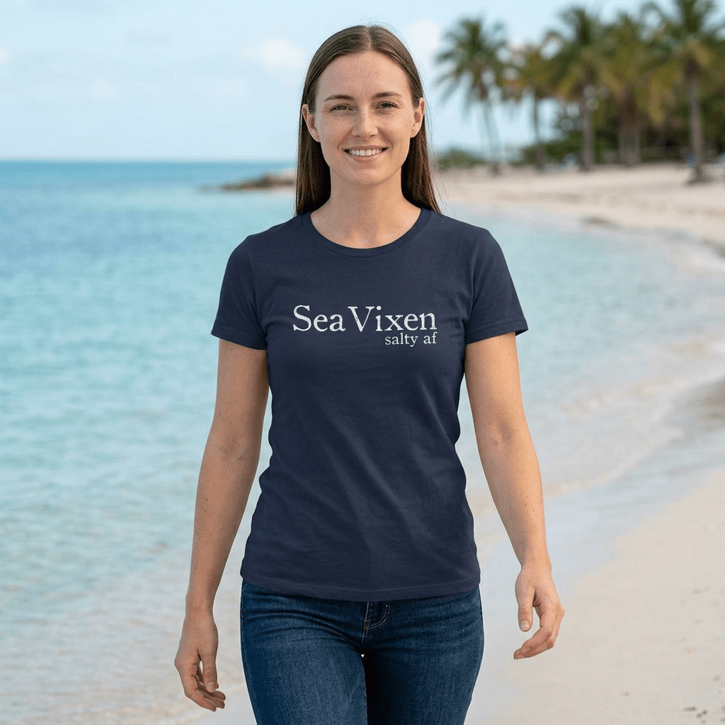 Woman wearing a navy blue t-shirt with 'Sea Vixen' text on a beach