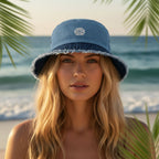 Beautiful blond sheller wearing a blue bucket hat with an embroidered sand dollar design on Anna Maria Island 