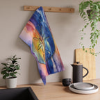 Colorful towel hanging on a wooden rack above a kitchen counter with plants and kitchenware.