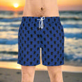 Man wearing dark blue board shorts with fun sea turtle pattern standing on an island beach at sunset