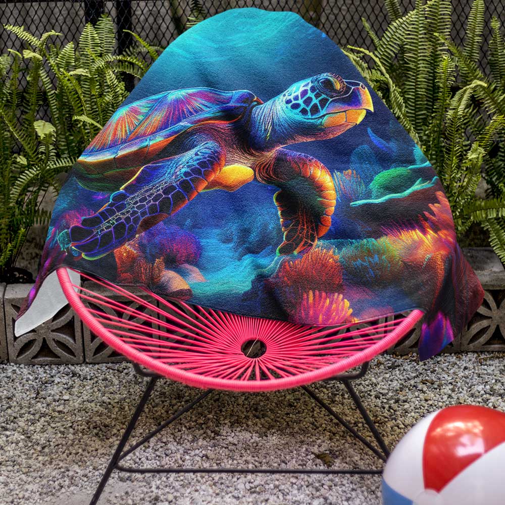Beautiful Sea turtle beach towel draped over a pool side chair.