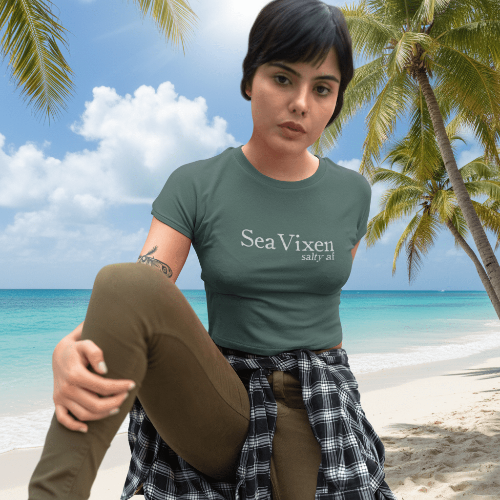 Woman wearing a green t-shirt with 'Sea Vixen' text, sitting on a Key West Beach