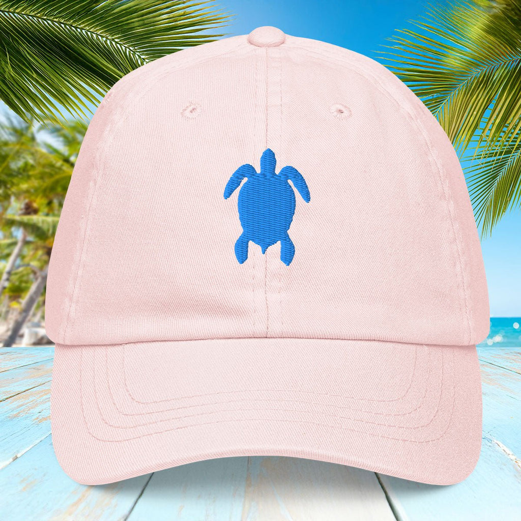 Pink cap with a blue turtle design on a tropical background