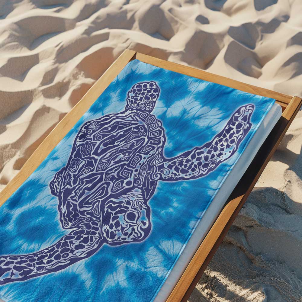 Zen Style Sea Turtle on a 2 Toned Tie Dye Beach Towel Laying across a wooden deck chair in the sand