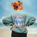 Person wearing a sweatshirt with 'Rod Reel Pier' and 'AMI TRON' text on a beach