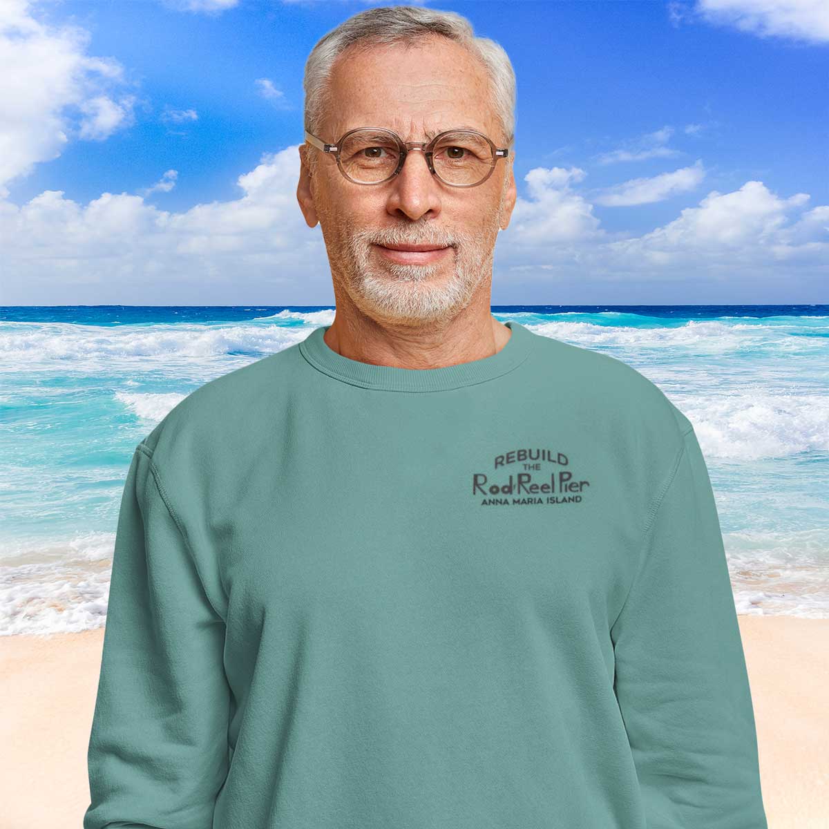 Man wearing a teal sweatshirt with text on a beach background