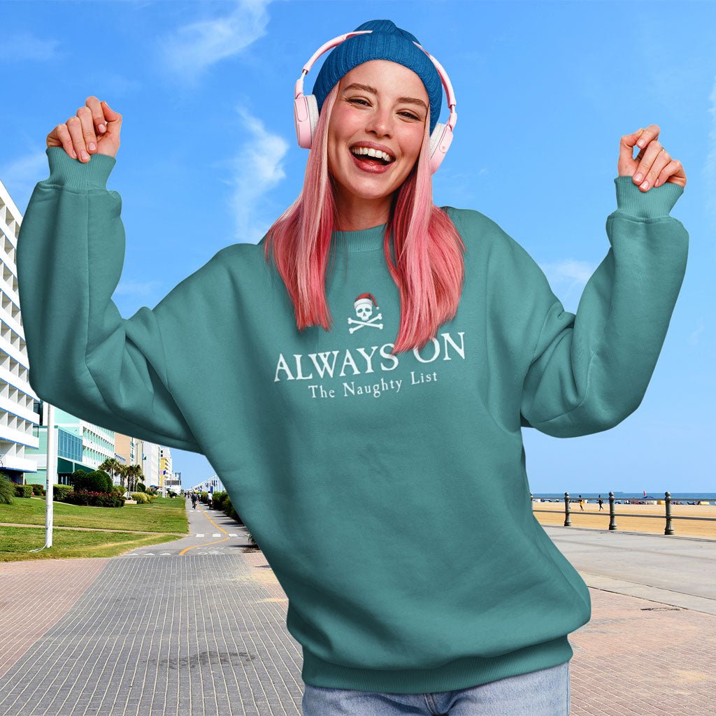 Person wearing a teal Naughty Pirate Sweatshirt with text, standing outdoors on a cool sunny day.