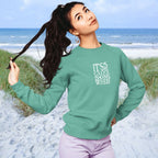 Woman wearing a green sweatshirt with text on a beach