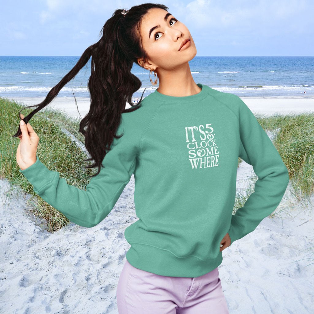 Woman wearing a green sweatshirt with text on a beach