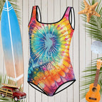 Vibrant tie dye swimsuit featuring a sweet seahorse silhouette in front of a rustic wood background with surfing icons all around. 