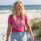 Woman wearing a pink t-shirt with text on a beach