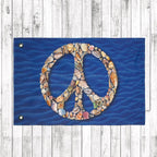 Peace symbol made of seashells on a blue fabric background