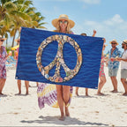 Peace symbol made of seashells on a blue fabric background