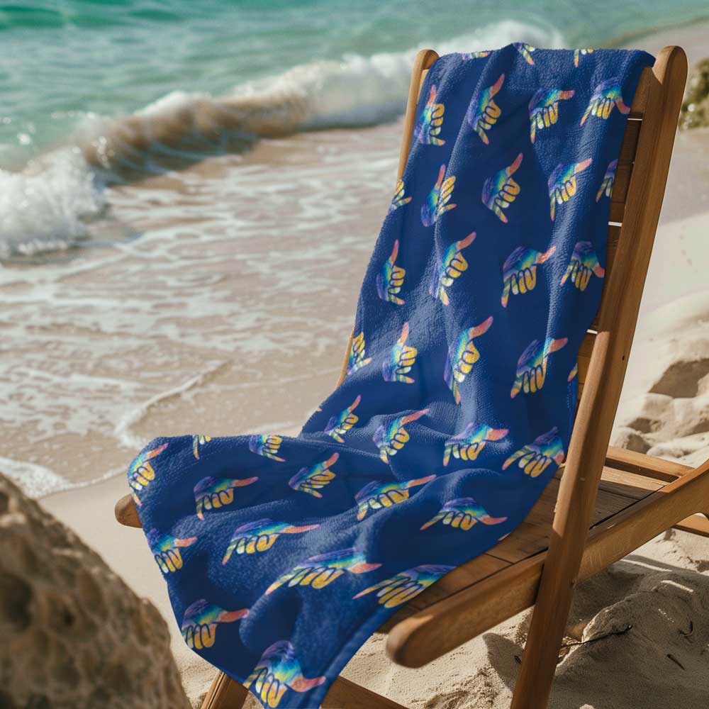 Shaka Beach Towel on wood beach chair next to water's edge