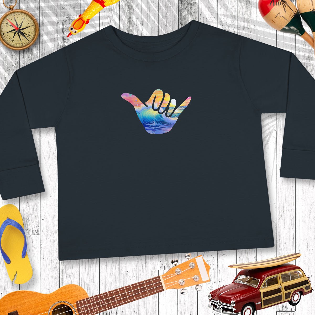 Black sweatshirt with a colorful hand gesture design on a wooden surface with beach-themed items.