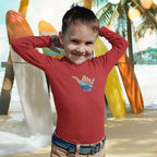 Child wearing a red shirt with a colorful design, standing in front of a tropical beach scene with palm trees and surfboards.