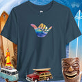 Navy blue Shaka Wave T-Shirt with colorful hand symbol design on a beach-themed background