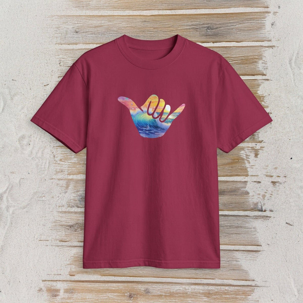 A short-sleeve crewneck t-shirt in maroon, featuring a colorful graphic of a hand sign with a sunset and ocean design, displayed flat against a rustic light wood background.