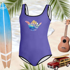 Royal blue swimsuit with rad shaka sign design on front. floating above the water's edge. palm frans peeking out from the sides of the image